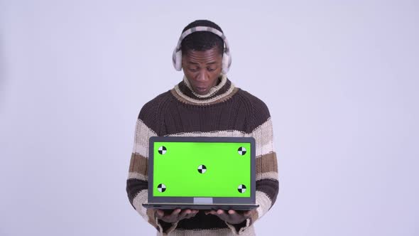 Young Happy African Man Showing Laptop and Looking Surprised Ready for Winter