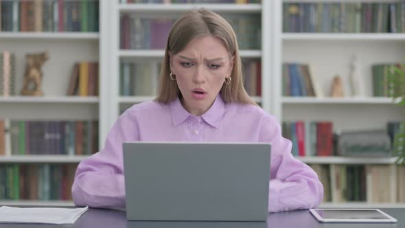 Woman Reacting to Loss While Using Laptop