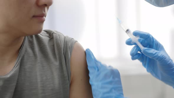 Close Up View of Medical Worker in Protective Gloves Disinfecting Skin Before Giving Vaccine Shot in