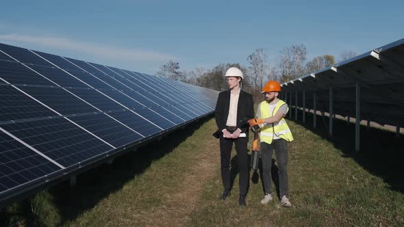 A Businessman and a Worker Are Walking on the Solar Power Station