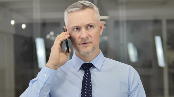 Grey Hair Businessman Negotiating with Customer During Phone Talk