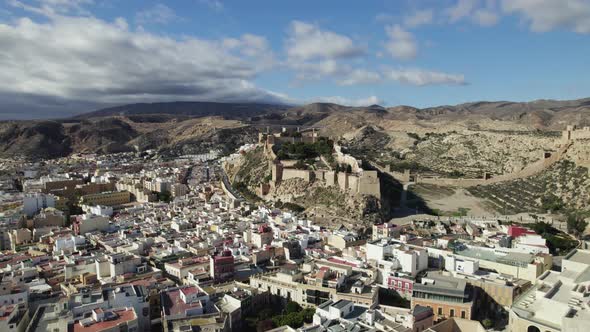 Aerial view over the cityscape, towards the Muralla de Jairán Castle in Almeria, Spain - circling, d