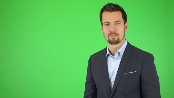 A Businessman Talks To the Camera and Presses Invisible Buttons in Front of Him with Two Fingers