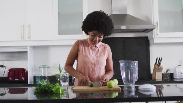 African american woman chopping vegetables in the kitchen at home