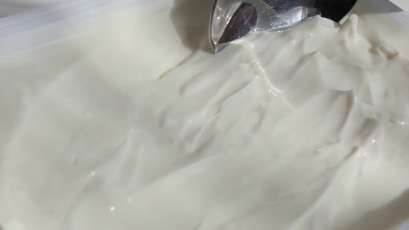 Close-up taking cream cheese with metallic  spoon slow-mo video