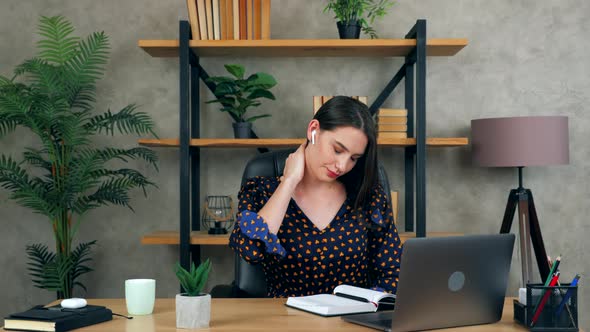 Tired beautiful businesswoman stretches massages neck pain after using laptop long time