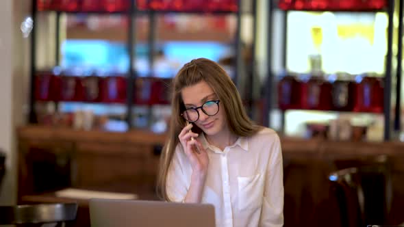 Girl Talking Phone In Cafe