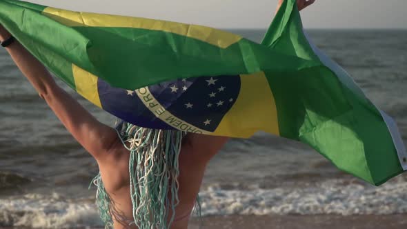 Beautiful Woman with the Flag of Brazil on the Sea Beach Slow Motion