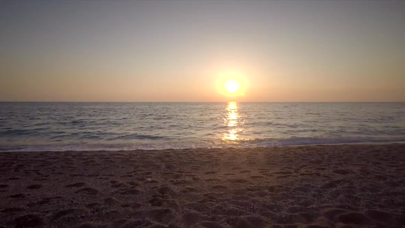 Aerial view of shore of the beach at sunset with few people in Lefkas island.