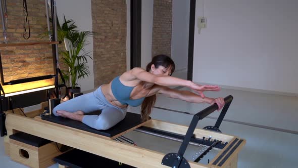 Woman stretching legs on pilates reformer