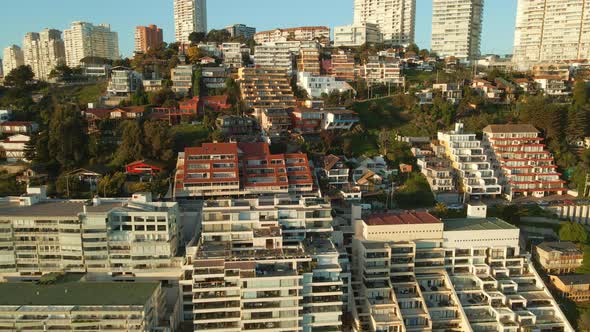 Aerial view reversing away from Reñaca coastal city buildings on Vina Del Mar beach resort waterfron