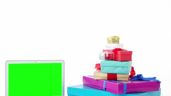 Stack of wrapped gift boxes with laptop