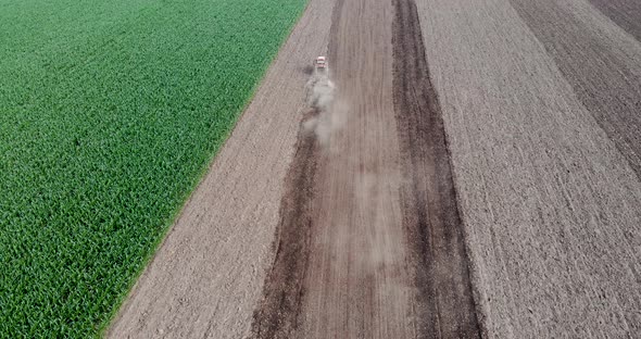 Following A Tractor Tilling Soil In The Farm