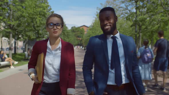 Diverse Business Colleagues in Conversation Walking on City Street