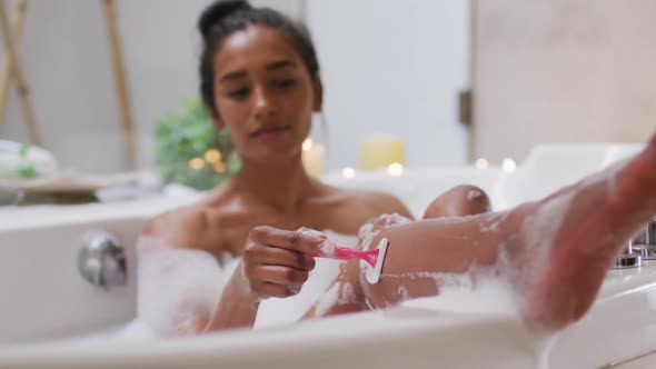 Mixed race woman lying in a bathtub at home