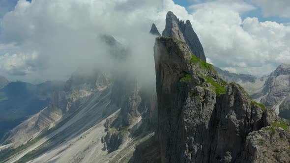 aerial rising above Jagged cliff edge of seceda mountain in dolomites