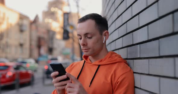 Man Listening to Music in Earphones on the Street