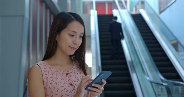 Woman use of mobile phone inside shopping mall