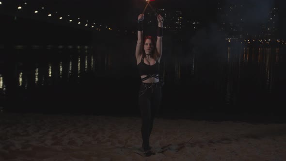 Pretty Firegirl Juggling Lit Torches Sitting Down