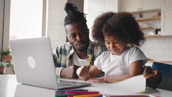 African American Girl and Her Daddy Video Calling to Family Daughter Showing Picture to Laptop Proud