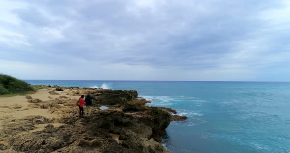 Couple standing on the rocky sea coast 4k