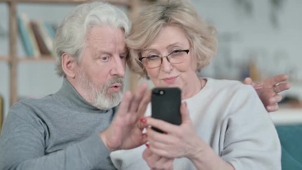 Old Couple Sitting Together and Using Smartphone