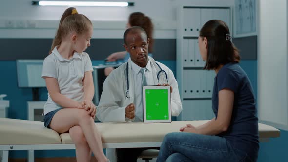 Tripod Shot of Doctor Using Green Screen Background on Tablet