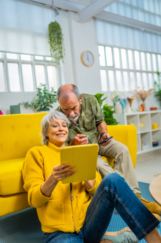 Senior couple commenting and sharing digital tablet at home