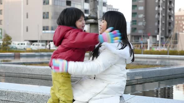 Asian Boy Hugging His Sister In The Park