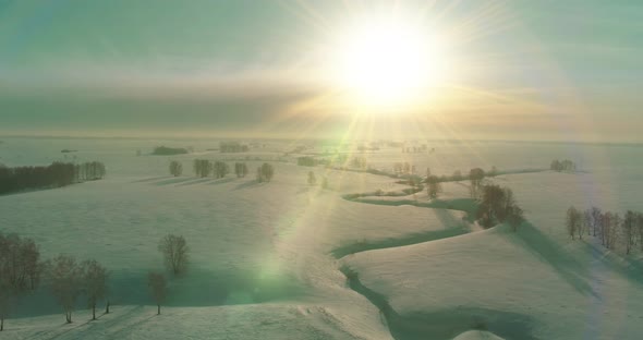 Aerial View of Cold Winter Landscape Arctic Field Trees Covered with Frost Snow Ice River and Sun