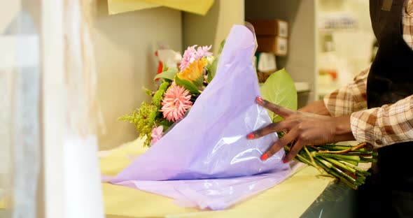 Female florist preparing flower bouquet in flower shop 4k