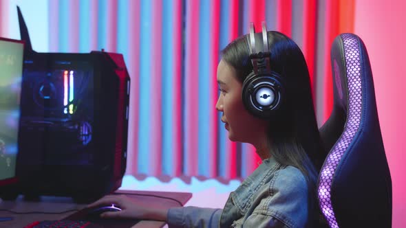 Young Gamer Girl With Headphones Plays Video Game