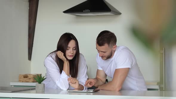 A man and a woman make an online order using a tablet