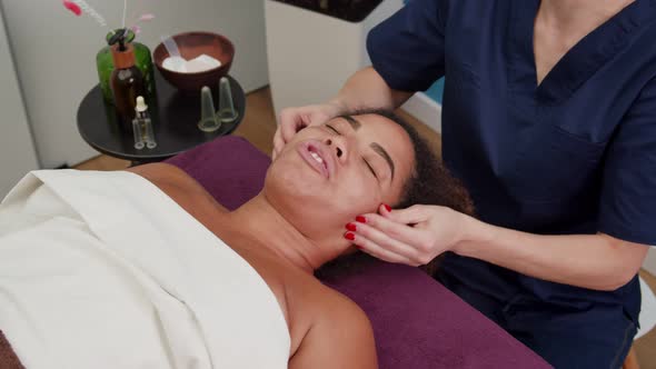 Attractive Young Adult Woman Having Face Massage in Spa Beauty Salon