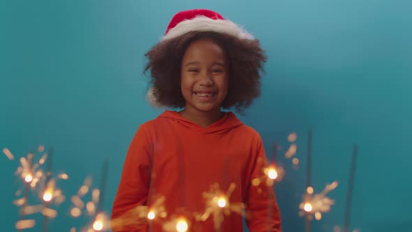 Happy African American girl in Santa's hat celebrating Christmas