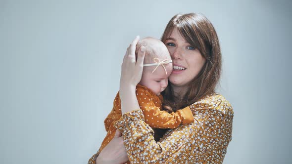 A Loving Mother Sings for Her Child Against a Gray Background