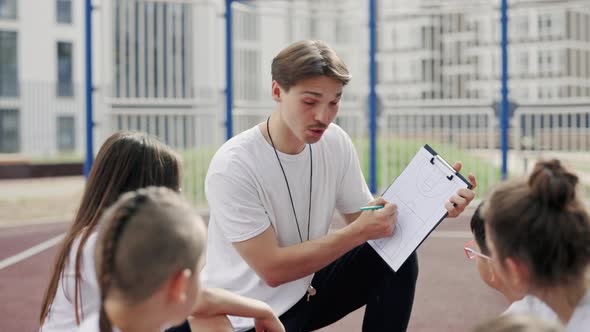 The Basketball School Coach Agrees the Game Plan with the Children Team Outdoor