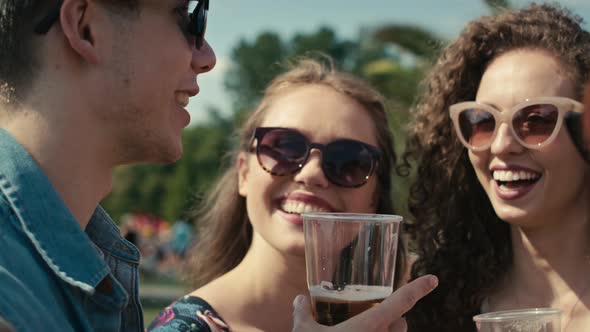 Group of friends spending time together at music festival and drinking beer. Shot with RED helium ca