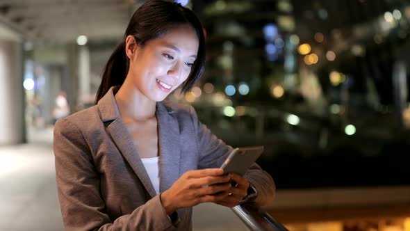 Young woman working on mobile phone at night 