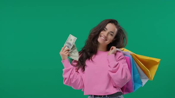 Young Girl with Shopping Bags and Bunch of Money in the Hands on Green Screen, Chroma Key
