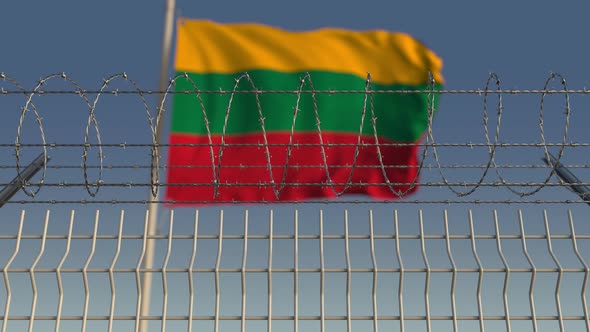 Waving Flag of Lithuania Behind Barbed Wire Fence