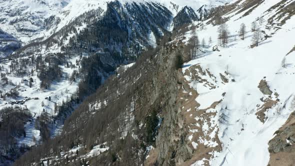 Tilt up from snow covered mountain edge to a distant Matterhorn