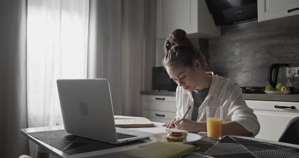 Young Woman Studying in Kitchen