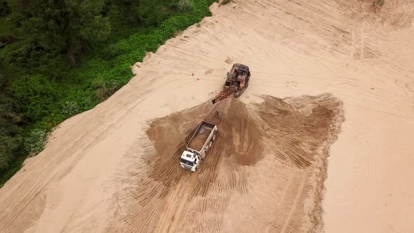 Aerial View of Excavator Pours Sand Into the Truck