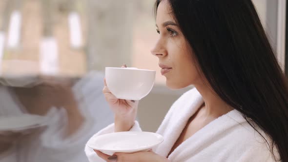 Pretty Young Lady Robe Drinks Coffee Dreams Near Window