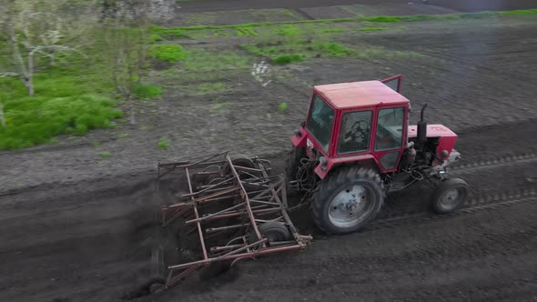 Agricultural Red Small Tractor in the Field Plowing