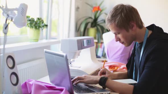 Fashion Designer with Laptop Working at Studio