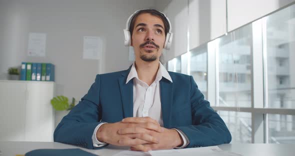 Young Businessman in Headphones Having Virtual Meeting on Laptop