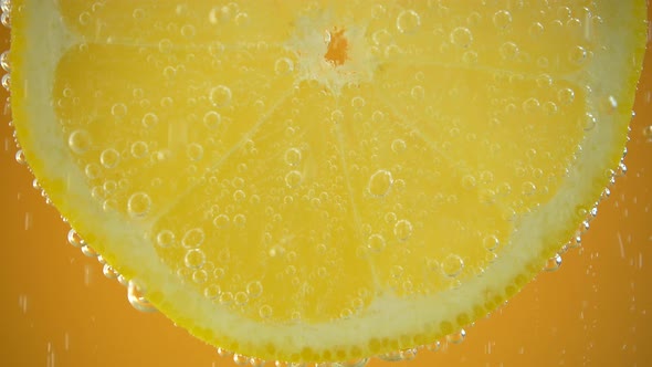 Air bubbles around a lemon slice.