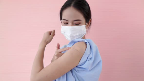 Young Asian Woman Showing COVID19 Vaccine Bandage Merrily